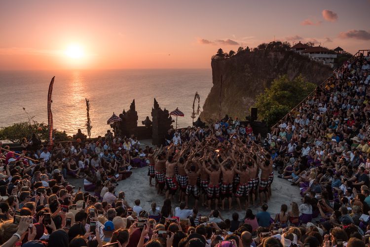 Ilustrasi tari kecak di Uluwatu, Bali, dengan latar matahari terbenam.