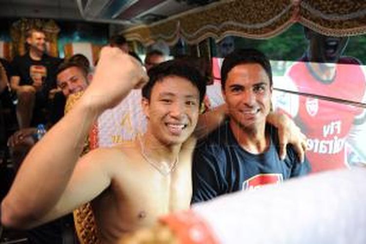 Seorang fans asal Vietnam (kiri) berfoto bersama Mikel Arteta (kanan) di dalam bus yang mengangkut rombongan Arsenal di Hanoi, Vietnam, Senin (15/7/2013). Fans yang diberi nama 