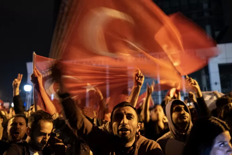 Ilustrasi bendera Turkiye dikibarkan massa.