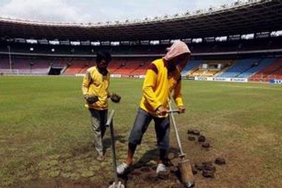 Petugas mengganti rumput yang rusak di Stadion Gelora Bung Karno, Jakarta Pusat, Senin (27/12/2010). Rumput rusak karena masuknya suporter ke lapangan hijau saat kericuhan pembelian tiket Final Piala AFF 2010 pada Minggu (26/12/2010) kemarin.