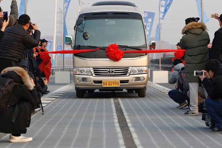 Sebuah mobil bersiap melintas di atas jalan berpanel surya di Jinan, provinsi Shandong, China, saat diresmikan pada 28 Desember 2017.