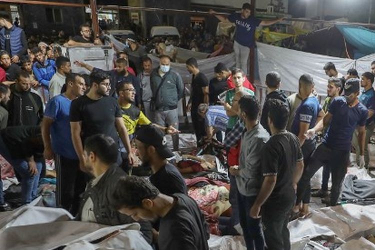 Orang-orang berkumpul di sekitar jenazah warga Palestina korban serangan rudal yang menghantam rumah sakit Ahli Arab di Gaza, Selasa (17/3/2023). Jenazah-jenazah ini kemudian dibawa ke rumah sakit Al Shifa.