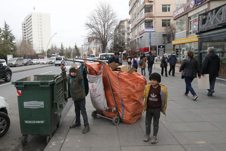 Dua anak pemulung menarik gerobaknya di sebuah jalan di Ankara pada 12 Januari 2021. [Adem ALTAN/AFP]