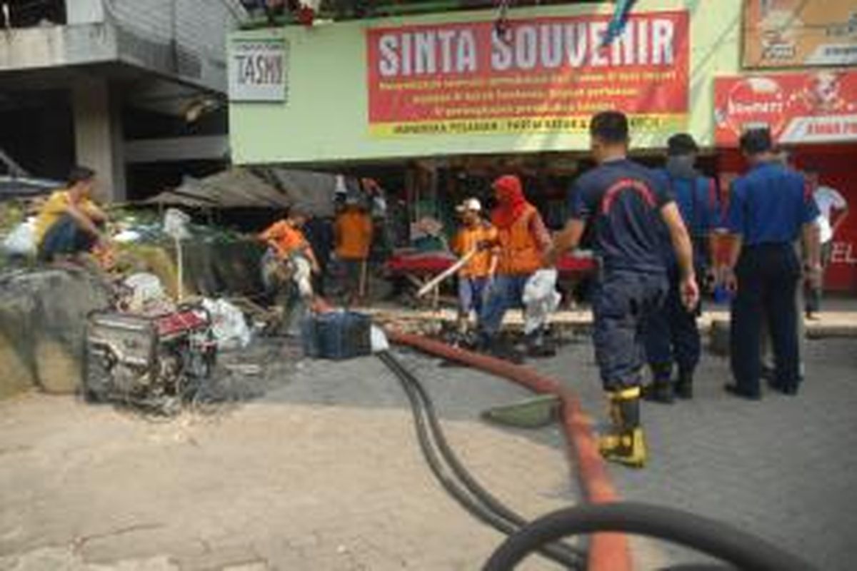 Petugas gabungan dari Dinas Pemadam Kebakaran dan Penanggulana Bencana  DKI Jakarta serta Dinas Pekerjaan Umum DKI Jakarta membersihkan got yang tersumbat dan berbau tak sedap di Pasar Blok G Tanah Abang, Jakarta Pusat, Selasa (13/8/2013).