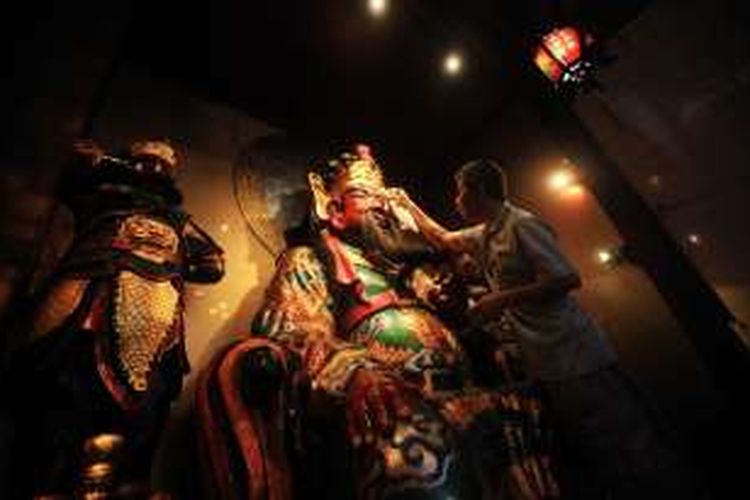 Petugas Kelenteng Darma Ramsi, Bandung, Jawa Barat, membersihkan patung dewa Kwan Kong di altar untuk menyambut peribadatan Tahun Baru Imlek, Rabu (3/2/2016). Selain pusat pertokoan dan rumah-rumah warga, tempat ibadah Kelenteng pun mulai persiapan menyambut perayaan Tahun Baru Imlek.