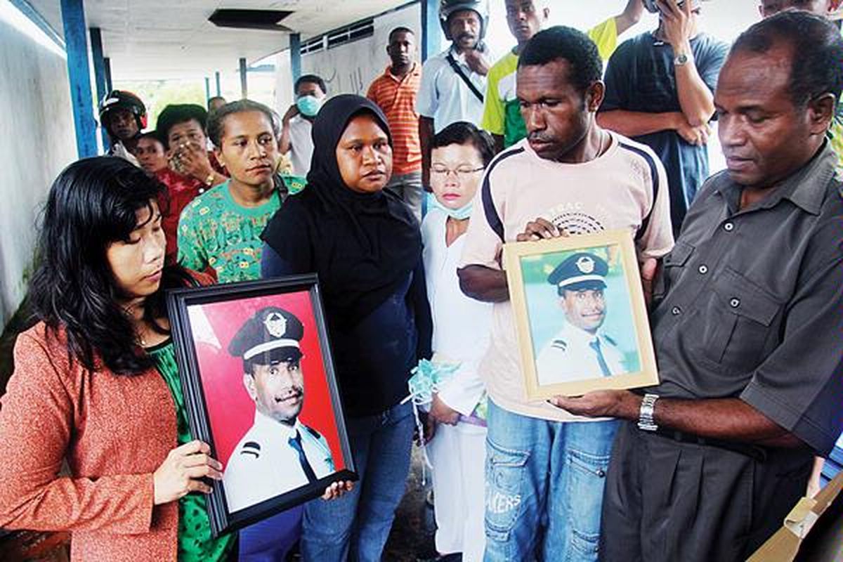 Asmalia (34, kiri), istri Paul Nap (36), terlihat tegar memegang foto suaminya saat berada di Puskesmas Kaimana, Rabu (11/5). Jenazah Paul dan Purwadi Wahyu (55), kemarin, akhirnya berhasil diangkat dari dasar laut. Paul dan Purwadi adalah kopilot dan pilot Merpati MA-60 yang jatuh di Perairan Kaimana, Papua Barat, pada Sabtu (7/5). Jenazah Paul langsung dikirim ke Wamena, kota kelahirannya, sedangkan jenazah Purwadi dikirimkan ke Jakarta.