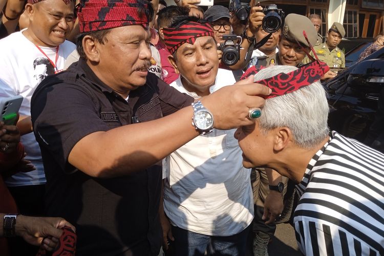 Bupati Nganjuk Marhaen Djumadi saat memakaikan udeng anjuk ladang ke Ganjar Pranowo, Jumat (23/6/2023)