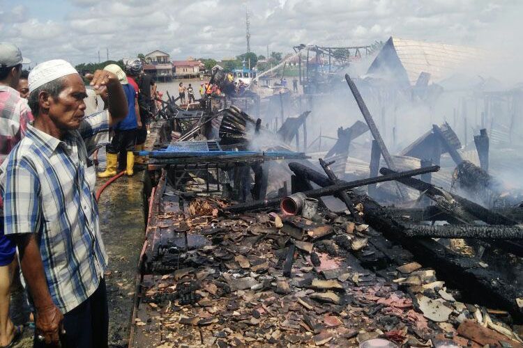 Salah satu warga sedang melihat kondisi rumahnya yang hangus terbakar di Jalan Aiptu A Wahab Lorong bersama-2 Rt 08 dan Lorong Intisari 4 Rt 11 Kelurahan 15 Ulu Kecamatan Seberang Ulu I Palembang, Sumatera Selatan, Kamis (17/5/2018).
