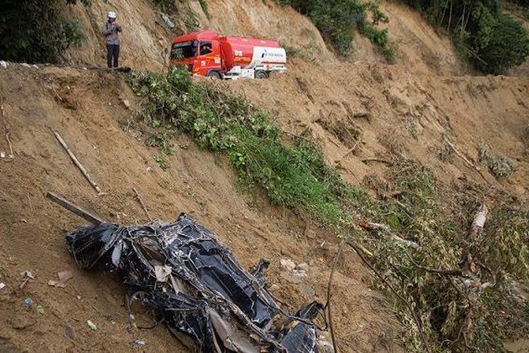 Warga mengamati kendaraan yang hancur terseret arus sungai Batang Tarusan pasca banjir bandang di Kecamatan Koto Sebelas Tarusan, Pesisir Selatan, Sumatera Barat, Senin (11/3/2024).