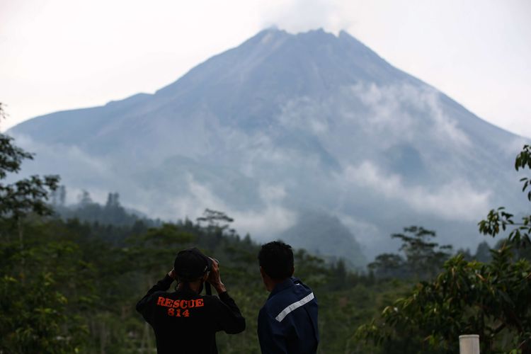 Petugas dan warga memantau perkembangan aktivitas Gunung Merapi dari Pos Pengamatan Gunungapi Merapi Babadan, Desa Krinjing, Kecamatan Dukun, Kabupaten Magelang, Jawa Tengah, Senin (16/11/2020). Sejak status Gunung Merapi ditingkatkan dari Waspada (Level II) menjadi Siaga (Level III), Kamis (5/11/2020), sebanyak 1.831 jiwa yang tinggal di lereng Gunung Merapi mengungsi.