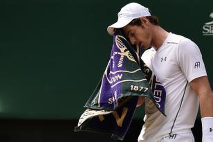 Petenis Inggris, Andy Murray, mengelap mukanya dengan handuk saat pertandingan semifinal Wimbledon melawan petenis Swiss, Roger Federer, di All England Tennis Club, London, Jumat (10/7/2015).