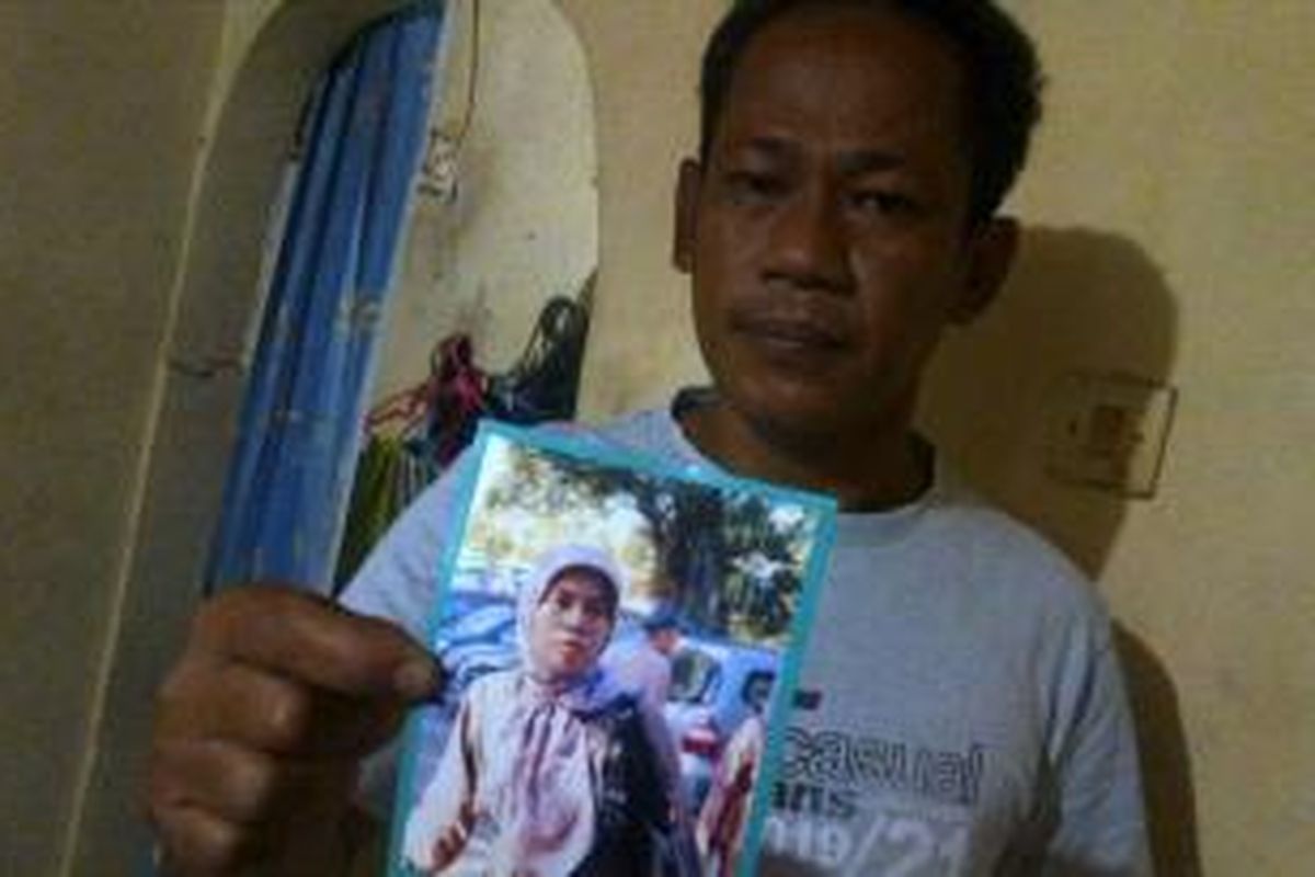 Syamsul (43), menunjukkan foto istrinya, Yayan Nurhayati (43), warga Jalan Kecubung 3 No 26 RT 04/09, Duren Sawit, Jakarta Timur, yang ditahan di Rutan Pondok Bambu, Rabu (8/1/2014). 