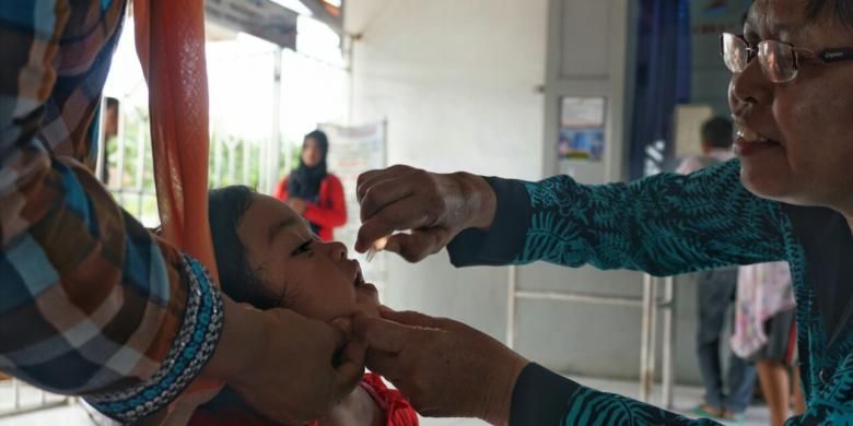 Seorang petugas sedang memberikan imunisasi seorang anak di Stasiun Temuguruh Banyuwangi pada Pekan Imunisasi Nasional 2016