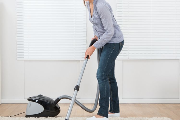 Ilustrasi membersihkan karpet dengan vacuum cleaner. 