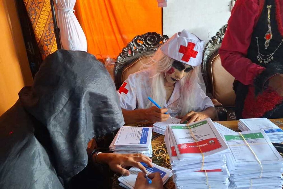 Petugas KPPS di TPS 5 Tepatnya di Jalan Raya Banjaran, Kampung Nambo, RT 03, RW 02, Desa Batukarut, Kecamatan Arjasari, Kabupaten Bandung, Jawa Barat mengenakan kostum hantu dan mendesain TPS seperti rumah hantu, Rabu (14/2/2024)