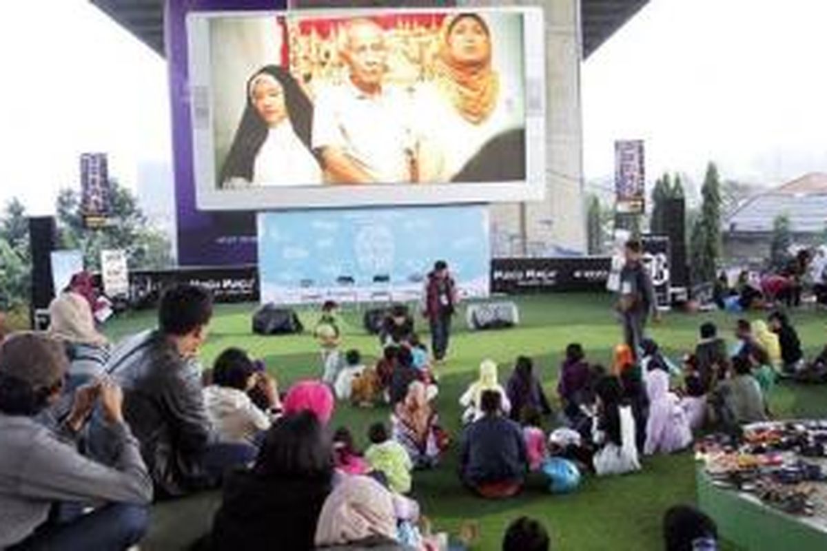 Warga menyaksikan penayangan film pada kegiatan 1.000 Wajah Bandung dalam rangka peringatan Hari Film Nasional di Taman Film, Bandung, Jawa Barat, Minggu (29/3/2015). Acara yang diselenggarakan Bandung Film Council itu bertujuan mempertemukan potensi beragam elemen ke dalam satu wadah guna mendorong Bandung sebagai kota sinema. 