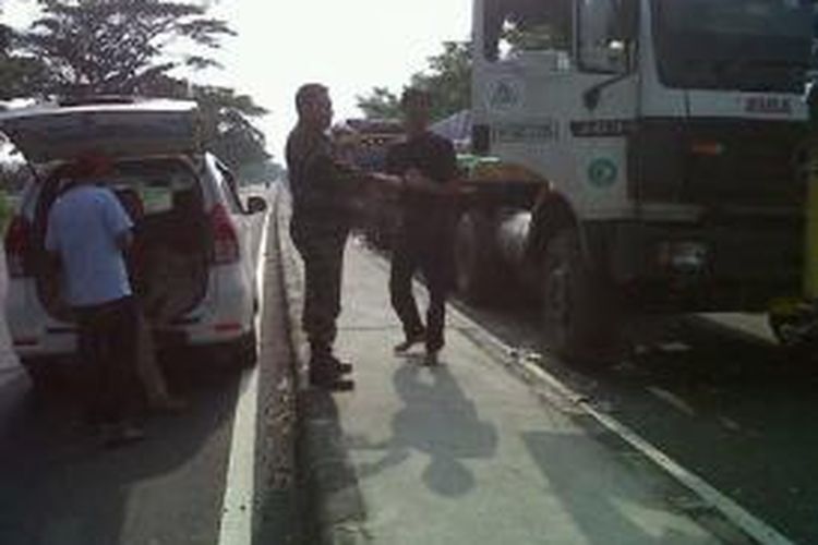 Anggota TNI Kodim 0716 Demak, memberikan nasi bungkus kepada sopir truk yang terjebak macet di jalan raya Demak-Kudus, Senin (27/1/2014)