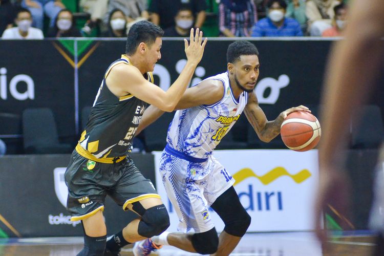 Pebasket Prawira Bandung Kenneth Jamal Wormley (putih) mencoba menghindari hadangan pebasket Dewa United Surabaya Dio Tirta Saputra (hitam), dalam gim ketiga Indonesian Basketball League (IBL) 2022 di Gor C-Tra Arena Bandung, Selasa (16/8/2022).