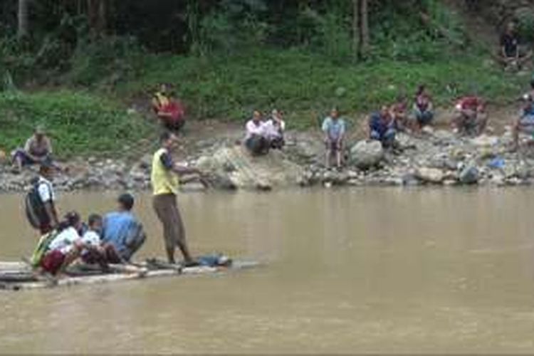 Sejumlah pelajar Sekolah Dasar naik rakit seadanya menyebrangi sungai seluas sekitar 100 Meter,Sedangkan para orang tua menunggu di pinggir sungai.