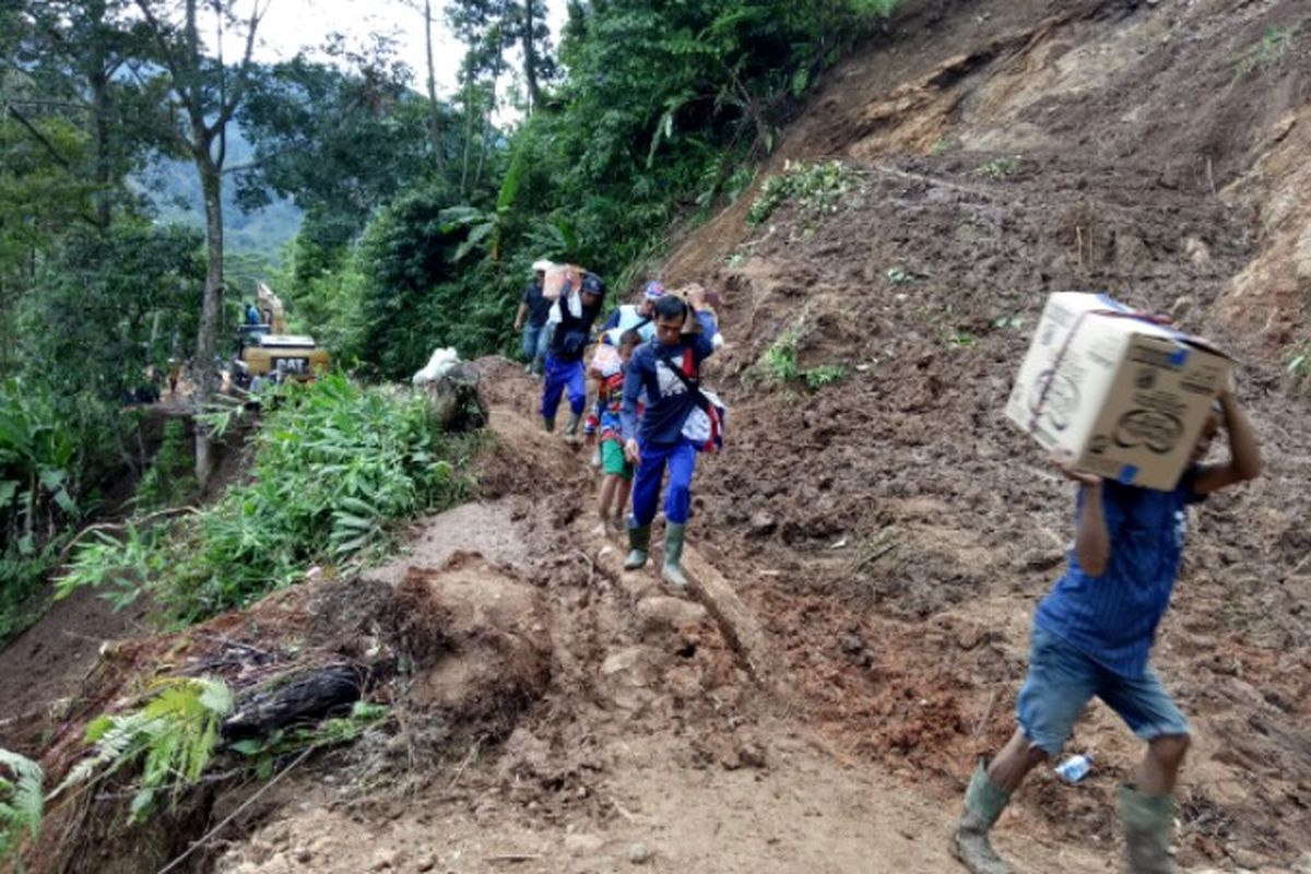 Jalur Penghubung menuju Kampung Gunung Julang, Desa Lebak Situ, Kecamatan Lebak Gedong, Kabupaten Lebak, Banten, tertutup tumpukan tanah longsor yang terjadi pada Rabu (1/1/2020), lalu. Hal tersebut membuat warga setempat membawa bantuan logistik dari para relawan sekitar 2 kilometer untuk sampai pengungsian. 