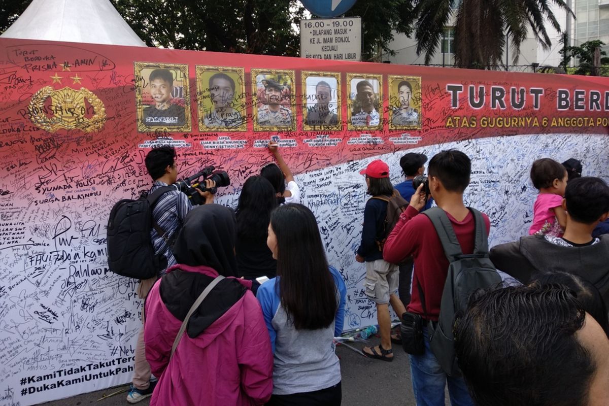 Warga berbondong-bondong ungkapkan bela sungkawa bagi anggota kepilisian yang gugur di Mako Brimob. Mereka menuliskan ungkapan duka di atas sebuah spanduk yang dibenatangan di CFD Minggu (13/5/2018).