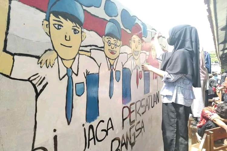 Salah satu SMPN 2 Dukuhwaru Tegal, Jawa Tengah melukis mural di salah satu tembok sekolah sebagai bentuk self healing siswa yang dilakukan sekolah memasuki masa PTM Terbatas. 