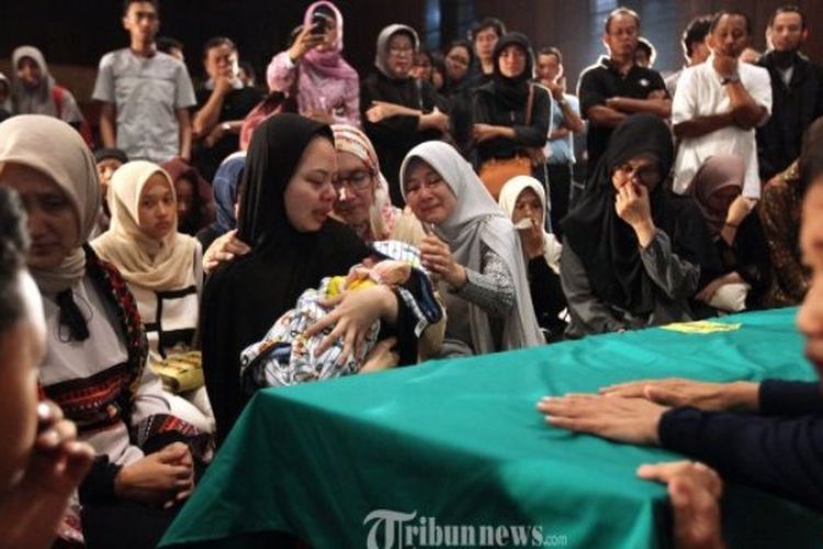 TANGIS HARU - Istri dosen Sekolah Bisnis Manajemen (SBM) ITB Suryo Utomo sambil menggendong bayinya menangis di depan peti berisi jenazah suaminya seusai disolatkan di Masjid Salman ITB, Jalan Ganeca, Kota Bandung, Minggu (14/5/2017) malam. Setelah disolatkan teman, kerabat, dan civitas akademika ITB di Mesjid Salman, jenazah bapak satu orang anak ini dimakamkan di TPU Cikutra. Suryo Utomo (30) sebelumnya dinyatakan hilang pada 10 Mei dan akhirnya ditemukan sudah tidak bernyawa oleh anggota Polsek Ciranjang di Waduk Cirata, Kabupaten Cianjur, Sabtu (13/5/2017) sore.