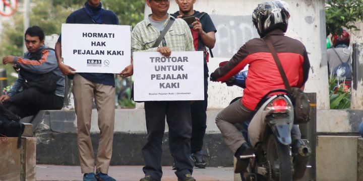 Sejumlah aktivis yang tergabung dalam Koalisi Pejalan Kaki menggelar aksi simpatik di kawasan Menteng Pulo, Jakarta, Jumat (21/7/2017). Aksi tersebut bertujuan untuk menuntut dikembalikannya fungsi trotoar bagi pejalan kaki.