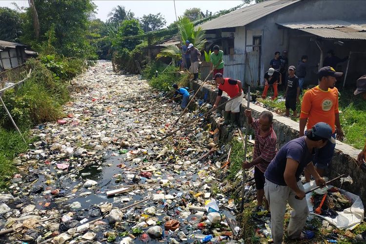 Warga bersama petugas koramil, kelurahan, dan Polsek Babelan membersihkan Kali Bahagia di Kabupaten Bekasi yang tertutup sampah, Selasa (30/7/2019), menggunakan peralatan sederhana.