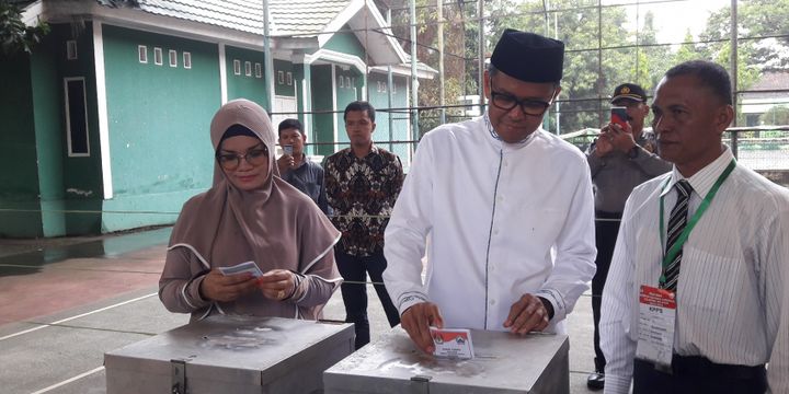 Calon Gubernur Sulawesi Selatan yang juga Bupati Bantaeng Nurdin Abdullah mencoblos bersama isteri di TPS dekat rumah dinasnya di Bantaeng, Rabu, (27/6/2018).