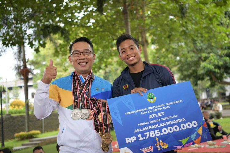 Gubernur Jawa Barat Ridwan Kamil menyerahkan bonus kepada Aflah fadlan Prawira sebagai atlet peraih medali terbanyak pada PON XX Papua 2021 di Gedung Sate, Kota Bandung, Rabu (27/10/2021).