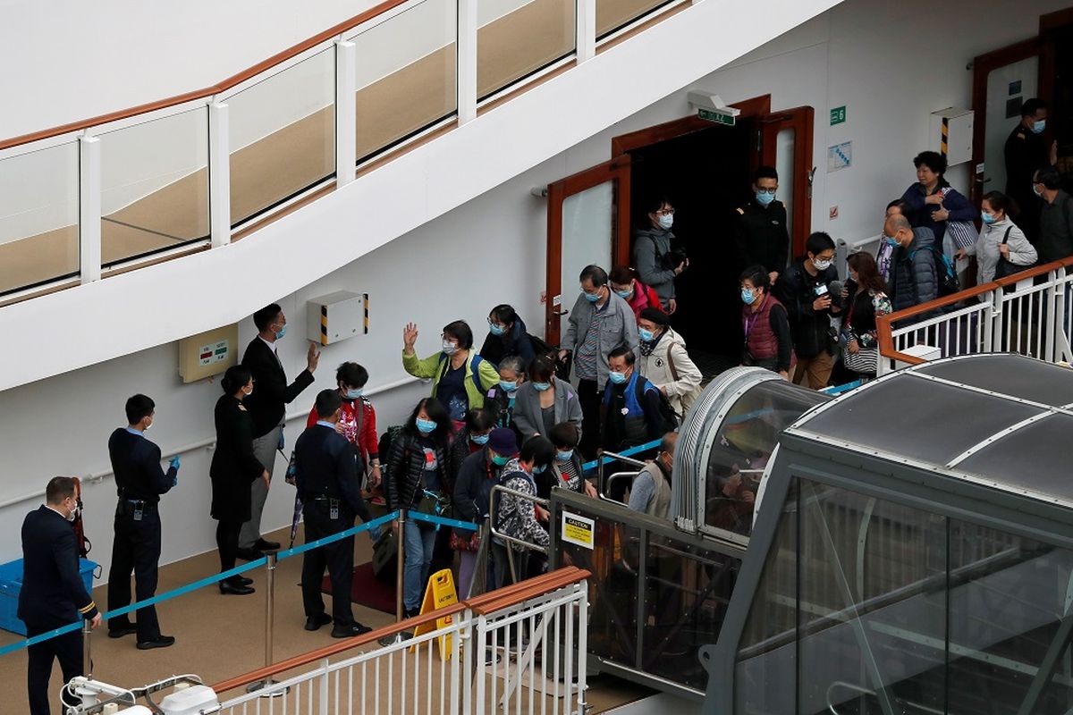Penumpang meninggalkan kapal pesiar World Dream setelah karantina untuk mencegah penularan virus korona baru di Kai Tak Cruise Terminal di Hong Kong, China, Minggu (9/2/2020). ANTARA FOTO/REUTERS/Tyrone Siu/aww/cfo