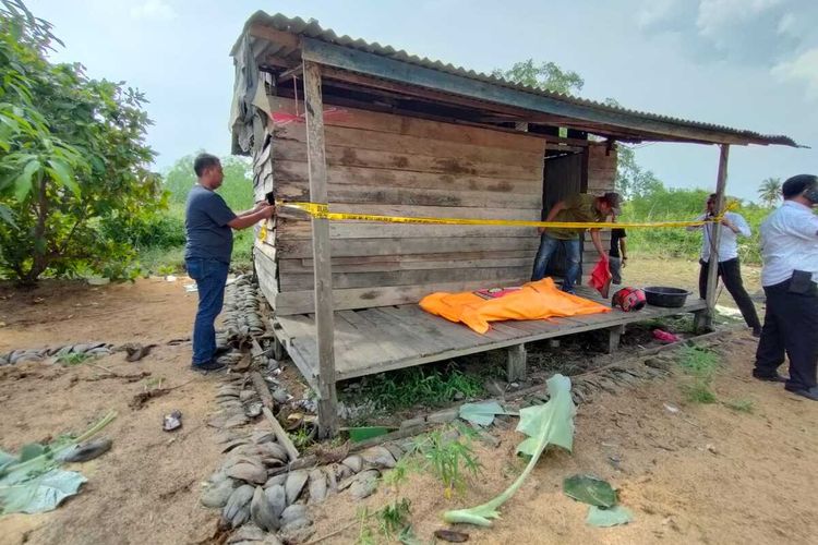 Petugas kepolisian memasang garis polisi pada rumah yang menjadi tempat bapak mutilasi anaknya di Kelurahan Tembilahan Barat, Kecamatan Tembilahan Hulu, Kabupaten Inhil, Riau, Senin (13/6/2022).