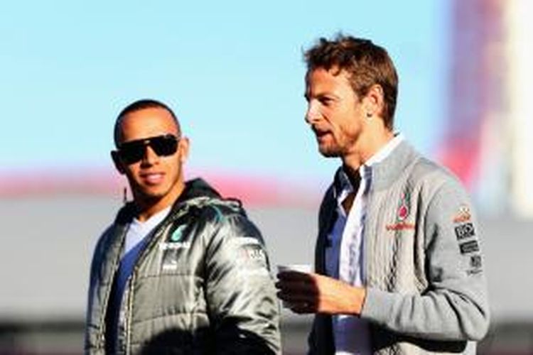 Pebalap McLaren asal Inggris, Jenson Button (kanan), berjalan di paddock bersama pebalap Mercedes yang juga berasal dari Inggris, Lewis Hamilton, saat sesi latihan bebas GP Amerika Serikat, di Sirkuit The Americas, Jumat (15/11/2013).