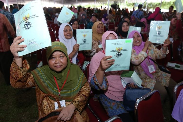 Sejumlah warga menunjukkan sertifikat tanah yang diberikan  Presiden Republik Indonesia Joko Widodo (Jokowi) saat acara penyerahan sertifikat tanah di Serpong, Tangerang Selatan, Banten,  Rabu  (11/10/1017). Jokowi  menyerahkan 10.100 sertifikat tanah kepada warga Tangerang Raya.