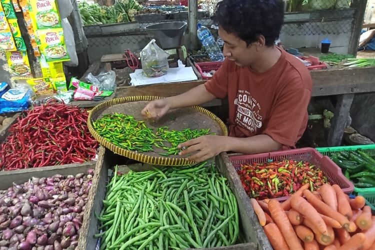 Penjual sayur bernama Dede sedang menyortir cabai yang busuk di Pasar Jombang, Ciputat, Tangsel, Selasa (22/2/2022).