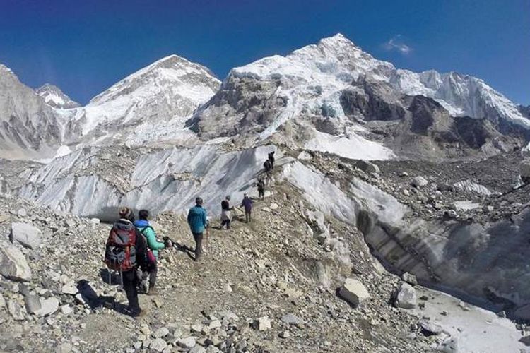 Pada hari Senin, 22 Februari 2016, para trekker melewati gletser di base camp Mount Everest, Nepal. Sepertiga dari gletser Himalaya akan mencair pada akhir abad ini karena perubahan iklim, mengancam sumber air bagi 1,9 miliar orang, bahkan jika upaya saat ini untuk mengurangi perubahan iklim berhasil, menurut penilaian yang dirilis Senin, 4 Februari, 2019 oleh Pusat Internasional untuk Pengembangan Gunung Terpadu.