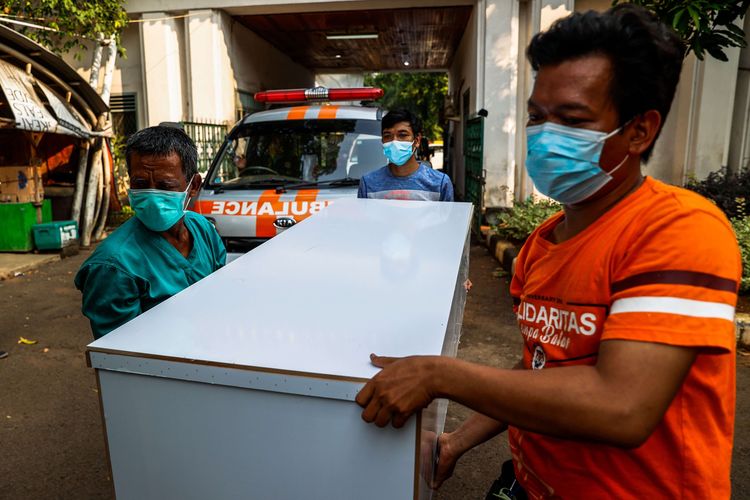 Pekerja mengangkat peti untuk dipindahkan ke mobil ambulans di TPU Petamburan, Jakarta Pusat, Minggu (4/7/2021). Dinas Pertamanan dan Hutan Kota DKI Jakarta menyiapkan peti Covid-19 untuk Rumah sakit dan pasien Covid-19 yang diisolasi di rumah di seluruh Jakarta.