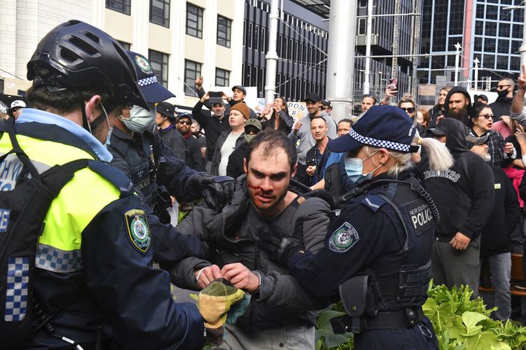 Seorang pengunjuk rasa, tengah, ditangkap oleh polisi dalam demonstrasi di Balai Kota Sydney selama demonstrasi anti-lockdown 'World Wide Rally For Freedom' di Sydney, Sabtu, 24 Juli 2021. 