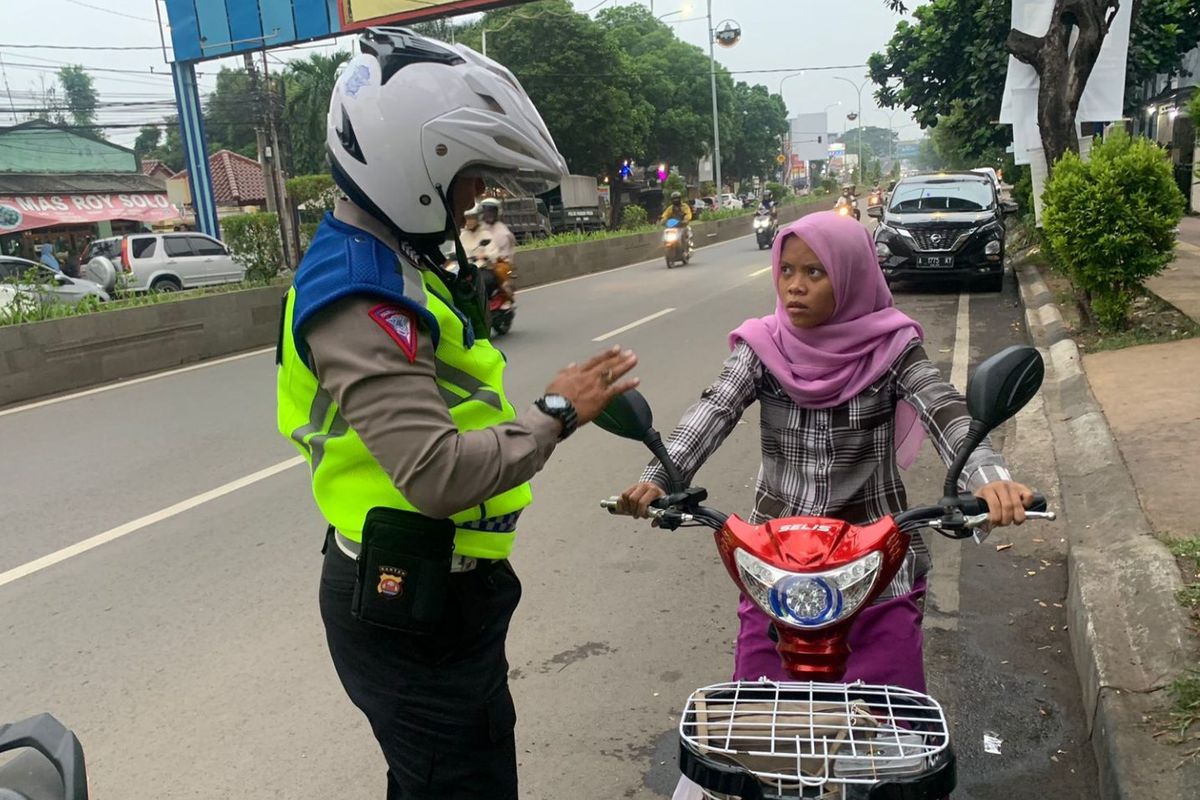 Aturan sepeda listrik di jalan raya. Anggota polisi menegur seorang pengendara sepeda listrik yang masuk jalan umum