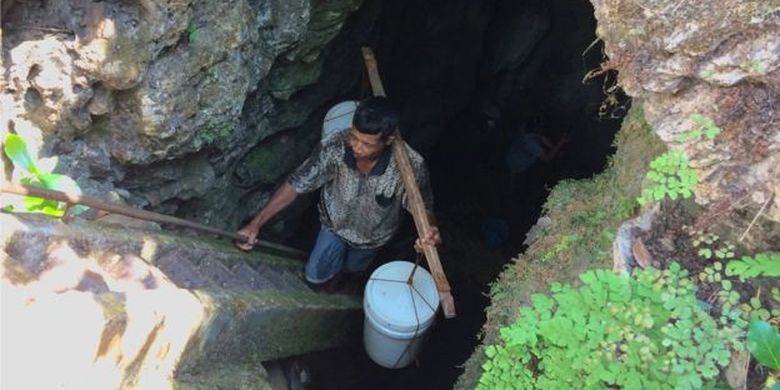 Seorang warga Desa Klepu, Pacitan, mengambil air bersih dari gua vertikal karena rumahnya belum mendapat pasokan air bersih PDAM. 
