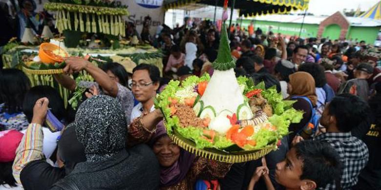 Warga berdesakan berusaha mengambil tumpeng dan makanan dalam acara Dhahar Kembul Sego Gurih yang digelar dalam arena Pasar Malam Perayaan Sekaten di Alun-alun Utara, Yogyakarta, Selasa (7/1/2014). Acara tersebut digelar antara lain untuk mempopulerkan kembali nasi gurih dan telur merah sebagai makanan khas dalam perayaan Sekaten.