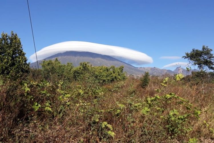 Warga menyaksikan fenomena topi awan yang melingkari puncak hingga lereng Gunung Rinjani, di Lombok, NTB, Rabu (17/7/2019. 