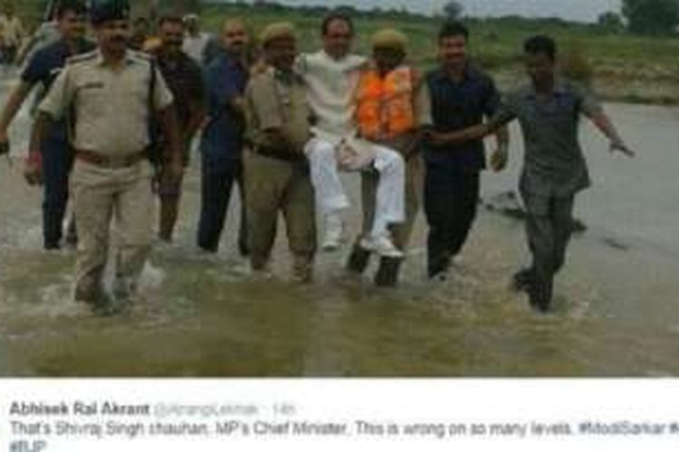 Shivraj Singh Chauhan, Menteri Besar Negara Bagian Madhya Pradesh, India tengah, digendong oleh perwira polisi di tengah banjir di wilayahnya