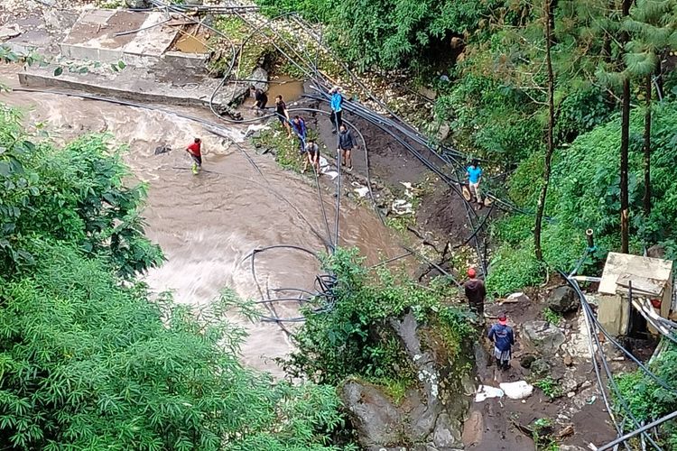 Sejumlah pekerja memperbaiki pipa saluran air bersih yang sempat rusak diterjang banjir bandang di aliran Sungai Gung, kawasan Objek Wisata Guci, Tegal, Jawa Tengah, Sabtu (25/2/2023)