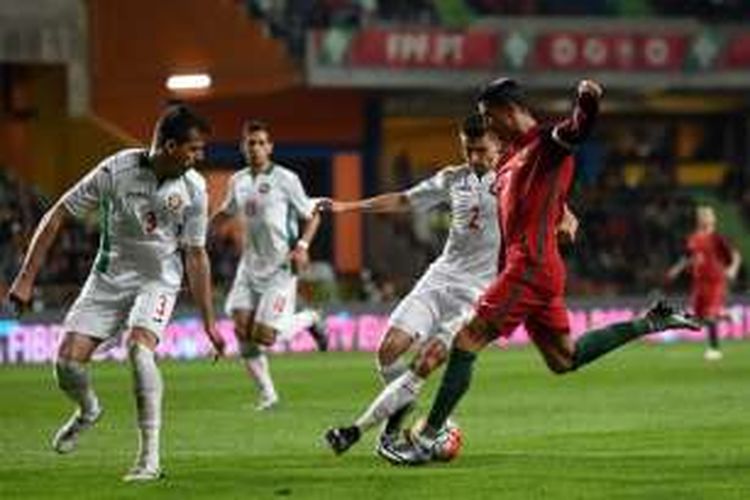 Kapten timnas Portugal, Cristiano Ronaldo (kanan), melepaskan tembakan di antara kepungan pemain Bulgaria dalam laga uji coba di Leiria, 25 Maret 2016.