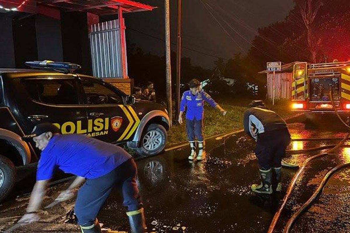 Para petugas Damkar Pemkab Bondowoso membersihkan ceceran solar di Jalan raya Bondowoso-Jember, Kecamatan Maesan, pada Senin (12/5/2025) malam. Akibat tumpahan solar itu, jalan menjadi licin dan banyak pengendara berjatuhan. 
