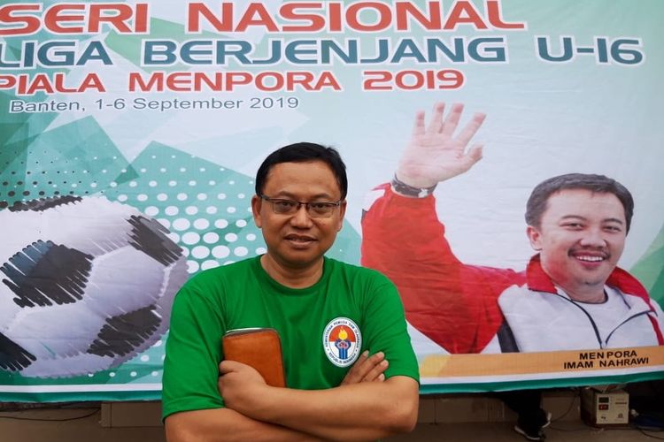 Pengamat sepak bola, Mohamad Kusnaeni berforo di depan banner Liga Berjenjang U-16 Piala Menpora 2019.