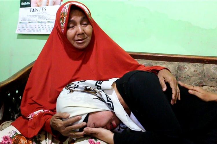 Turini (43) bersimpuh di pangkuan ibunya  Syiah (68) di rumahnya di Desa Dawuan Kecamatan Plered Kabupaten Cirebon, Senin (22/7/2019). Turini kembali menginjakkan kedua kakinya di rumah setelah 21 tahun menjadi Pekerja Migran Indonesia.