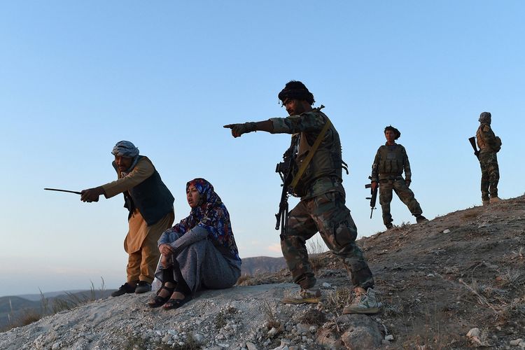 Foto pada 14 Juli 2021 memperlihatkan Salima Mazari (dua dari kiri), gubernur wanita di distrik Afghanistan yang didominasi pria, mengamati sisi bawah bukit dengan ditemani personel keamanan dekat garis depan pertempuran melawan Taliban di distrik Charkint, provinsi Balkh.